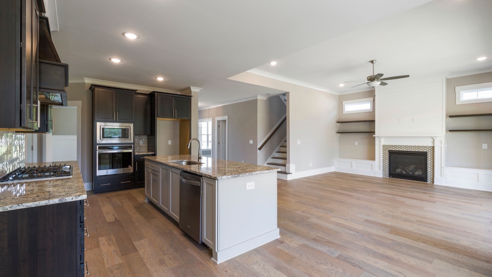 Open-concept kitchen and living room with a flat drywall ceiling, the kind of open layout a DIY multi zone ceiling cassette mini split is built for