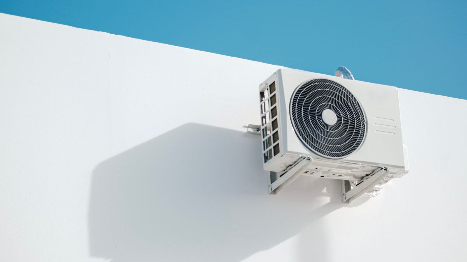 Best DIY multi zone mini split: outdoor heat pump condenser mounted on an exterior wall, the one unit that serves every indoor zone