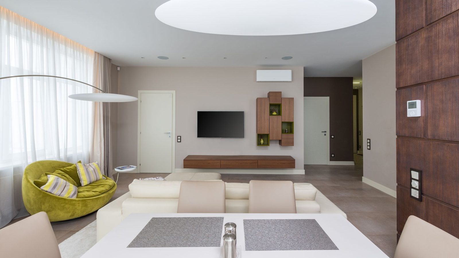 White smart thermostat with digital display mounted on dark wood wall, a best heat pump thermostat 2026 candidate