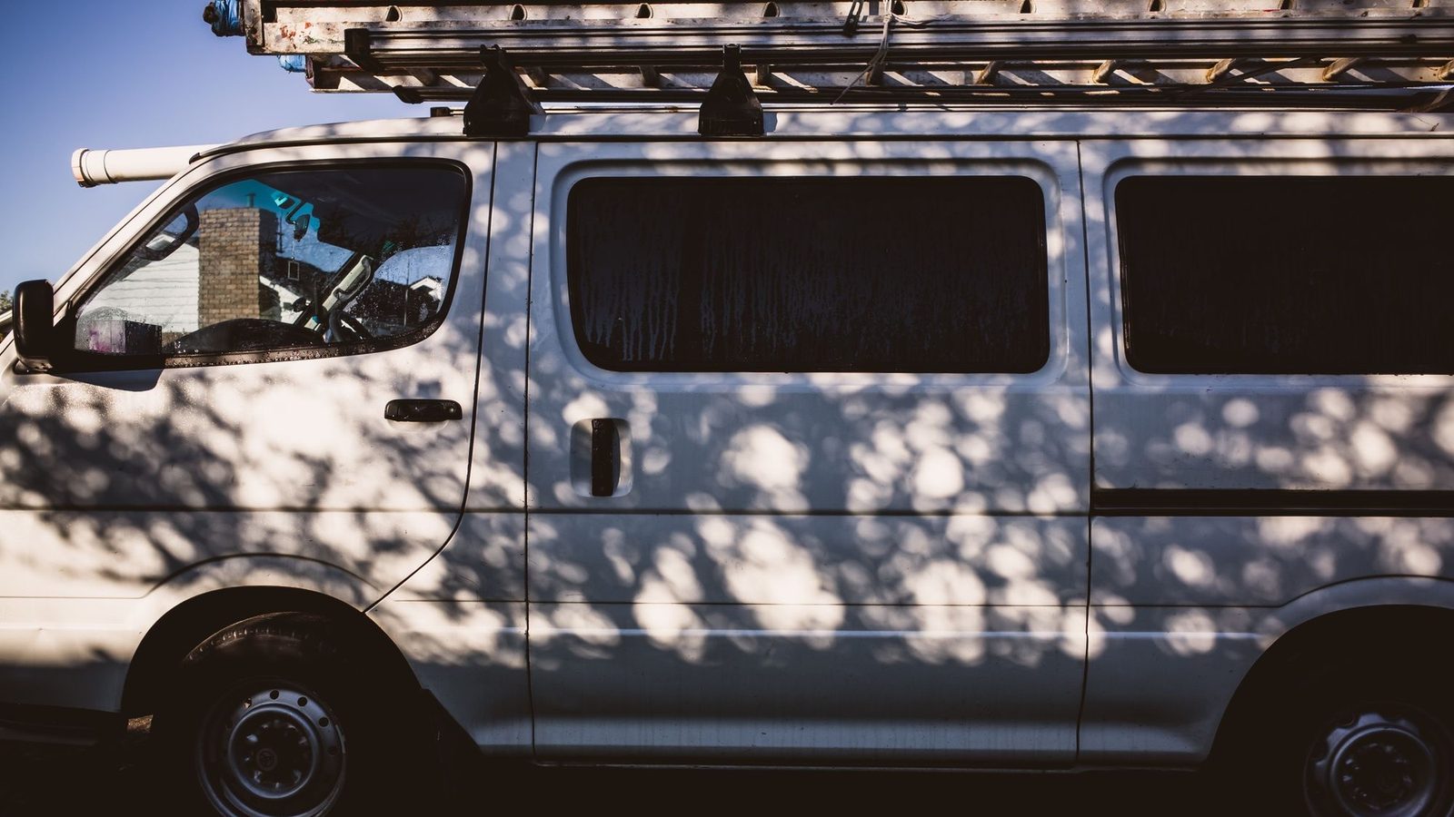 White commercial work van with a roof ladder, used by technicians who buy hvac equipment online