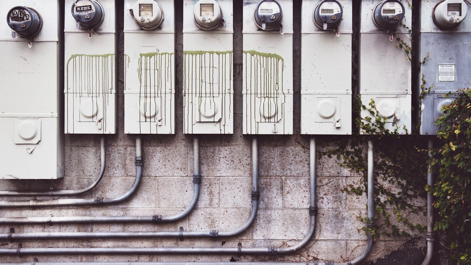 Outdoor electrical meter boxes and disconnect panels on a concrete wall, demonstrating how to wire an ac disconnect box setup